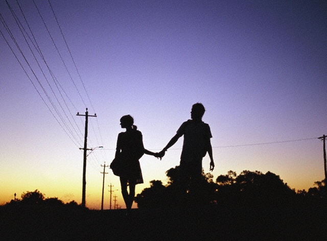 Two People Holding Hands On The Beach. But still I look back